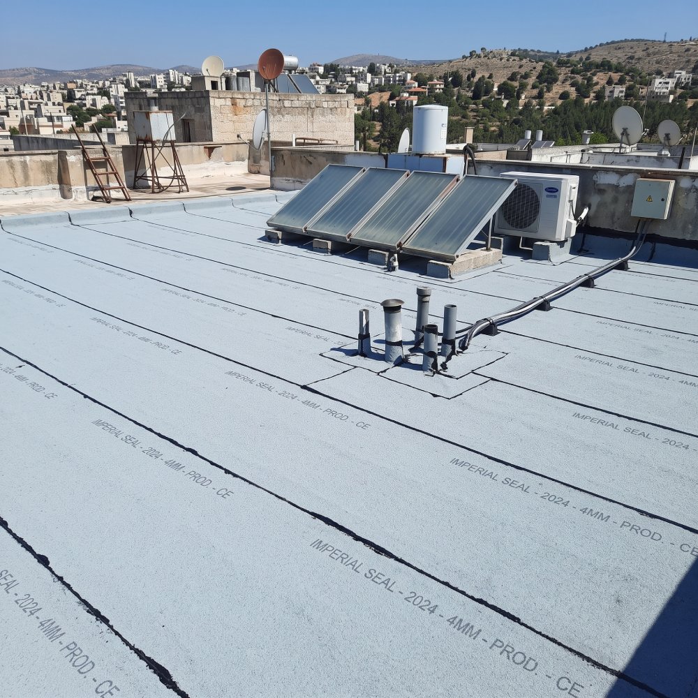 גג שטוח מכוסה יריעות ביטומניות עם הטבעת יצרן, ואיטום סביב צרור צינורות בולטים